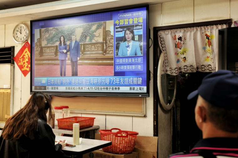 La rencontre entre le président chinois Xi Jinping et Cheng Li-wun, cheffe du principal parti d'opposition taïwanais KMT, diffusée à la télévision dans un restaurant de Taipei, le 10 avril 2026 ( AFP / I-Hwa Cheng )