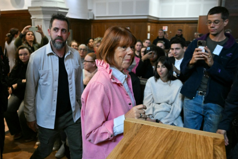 Gisèle Pelicot (c) et son fils Florian Pelicot (g) entrent dans la salle d'audience pour assister au procès en appel des viols de Mazan au palais de justice de Nîmes, le 9 octobre 2025 dans le Gard ( AFP / Christophe Simon )