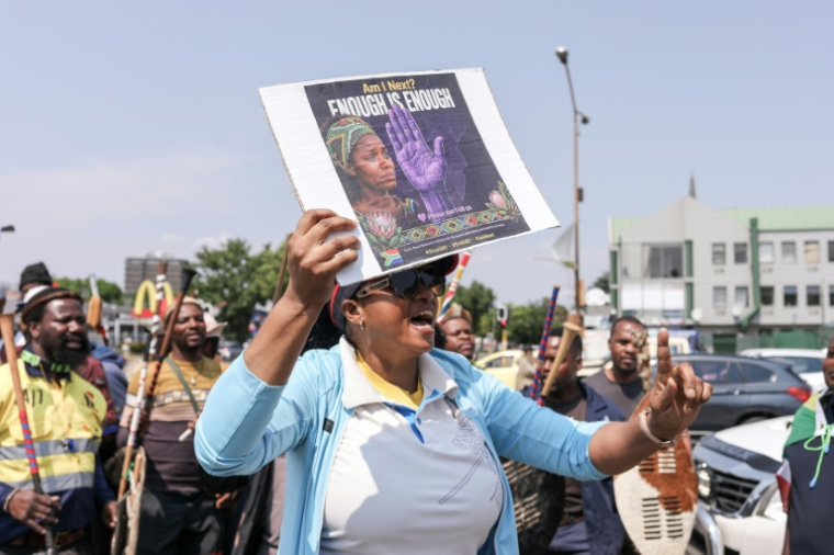 Une femme brandit une pancarte sur laquelle est écrit "Suis-je la prochaine ? Assez, c'est assez", lors d'une marche de protestation à Kempton Park, près de Johannesburg, le 19 septembre 2026, après une série de meurtres de femmes survenus dans la région ( AFP / MZINGENKOSI SIBANDA )