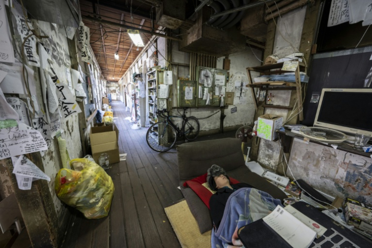 L'étudiant Rintaro Yoshida dort dans un couloir du Foyer Yoshida de l'université de Kyoto, le 4 février 2026 au Japon ( AFP / Yuichi YAMAZAKI )