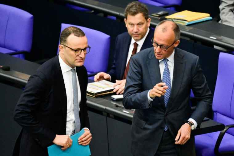 Le chancelier allemand Friedrich Merz (D) et le chef des députés conservateurs allemands, Jens Spahn (G), le 11 juin  2026 au Bundestag à Berlin ( AFP / John MACDOUGALL )