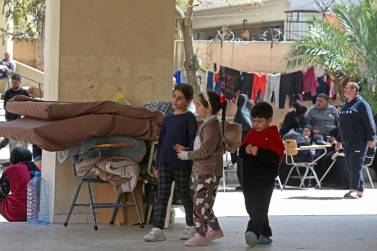 Des enfants déplacés du sud du Liban marchent dans la cour d'une école transformée en abri à Sidon, ville côtière du sud du pays, le 18 mars 2026 ( AFP / MAHMOUD ZAYYAT )
