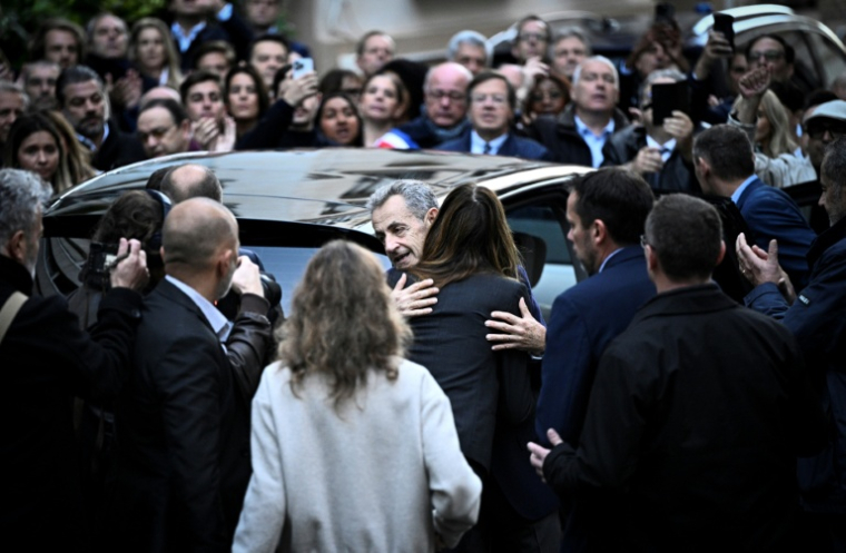 Nicolas Sarkozy dans les bras de son épouse Carla Bruni, avant son incarcération le 21 octobre 2025 à Paris ( AFP / JULIEN DE ROSA )