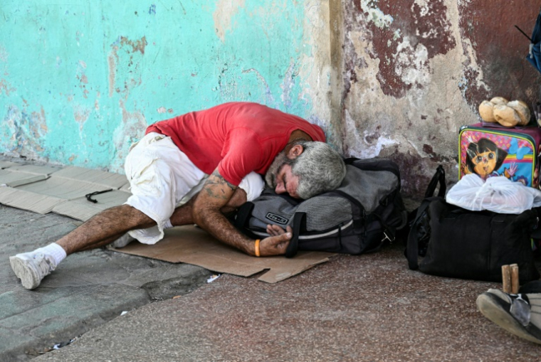 Un sans-abri dort dans une rue de La Havane, le 21 juillet 2025 à Cuba ( AFP / Yamil LAGE )