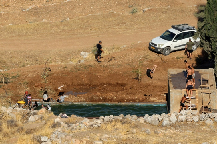 Des colons israéliens se baignent dans la source d'Ein Samiyah, près du village de Kafr Malik, en Cisjordanie occupée le 15 juillet 2025 ( AFP / Zain JAAFAR )