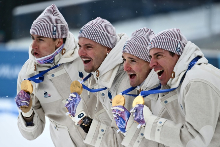 Les Français Eric Perrot, Emilien Jacquelin, Fabien Claude et Quentin Fillon Maillet (de gauche à droite) avec leurs médailles d'or de champions olympiques de relais le 17 février 2026 à Anterselva ( AFP / Marco BERTORELLO )