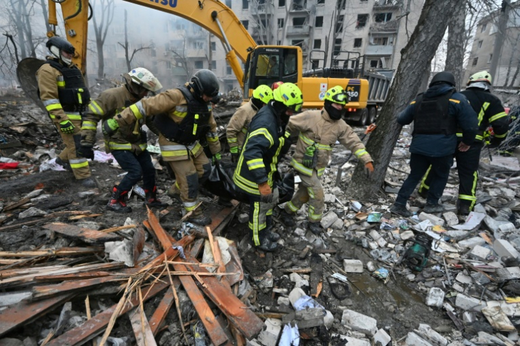 Des sauveteurs évacuent un corps extrait des décombres d'un immeuble touché par un bombardement à Kharkiv, dans l'est de l'Ukraine, le 7 mars 2026 ( AFP / SERGEY BOBOK )