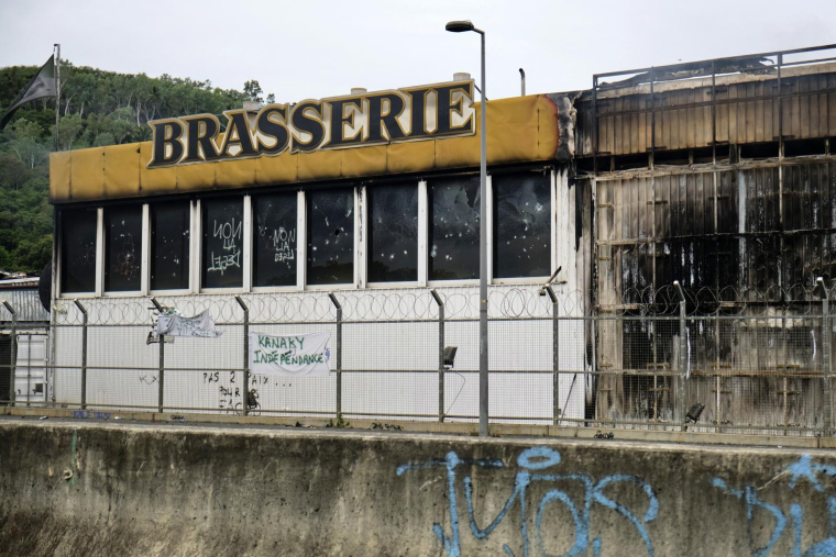 Cette photo montre la façade d'une brasserie incendiée lors d'émeutes à Nouméa, dans le territoire français du Pacifique en Nouvelle-Calédonie, le 28 mai 2024. ( AFP / THEO ROUBY )