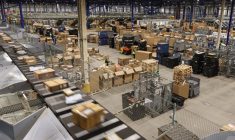 Un employé de la société de livraison de colis Mondial Relay passe devant des colis empilés sur le site situé à Harnes (Pas-de-Calais), le 5 décembre 2023.  ( AFP / DENIS CHARLET )