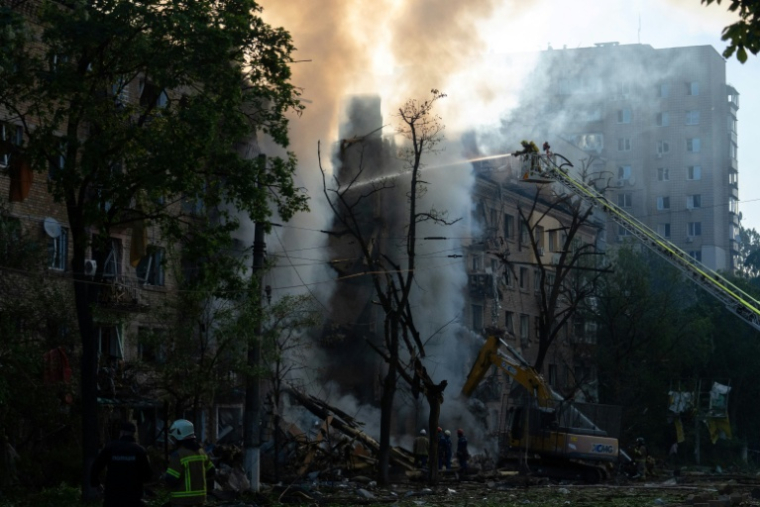 Des pompiers luttent contre l'incendie d'un immeuble après d'intenses bombardements russes nocturnes, le 24 mai 2026 à Kiev   ( AFP / OLEKSII FILIPPOV )