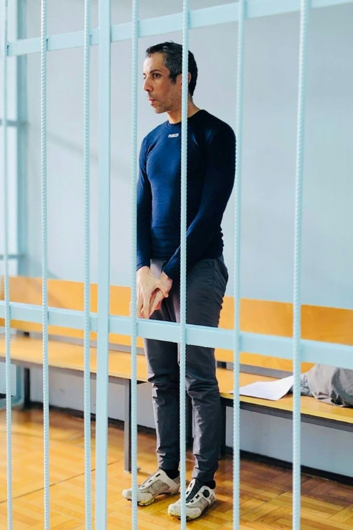 Photo du 23 octobre 2025 publiée par le service de presse unifié des tribunaux de la région de Primorié, montrant le cycliste français Sofiane Sehili, arrêté pour suspicion d'avoir traversé illégalement la frontière russe, dans la cage des accusés lors d'une audience au tribunal dans la colonie extrême-orientale de Pogranitchny ( Service de presse unifié des tribunaux de la région de Primorié / Handout )
