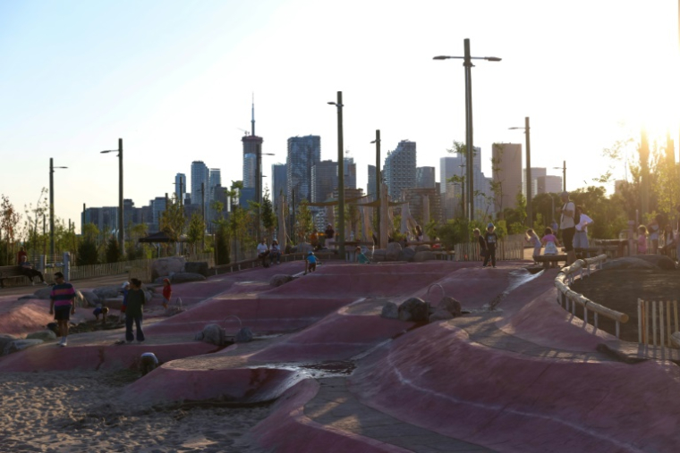 Des enfants jouent dans le nouveau parc Biidaasige, qui fait partie du projet de protection contre les inondations des terrains portuaires de Toronto. ( AFP / Cole BURSTON )