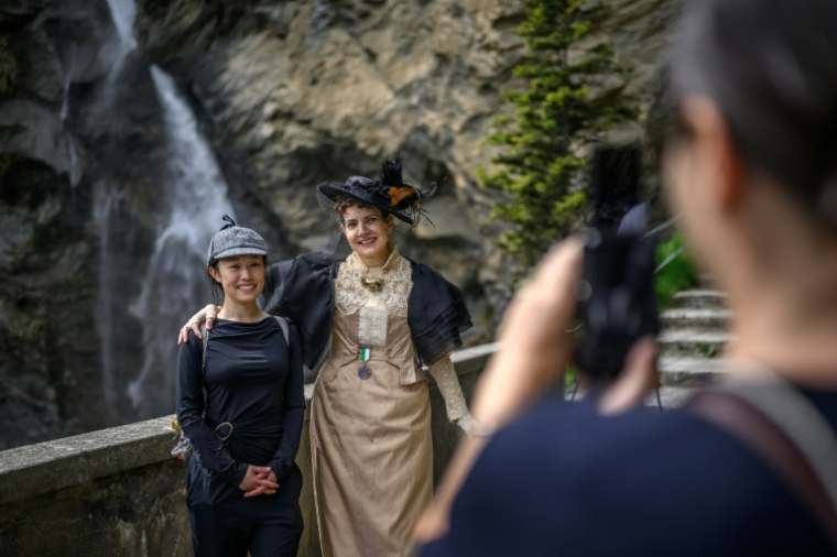 Kitty (g) fan chinoise de Sherlock Holmes, pose au côté d'une membre de la Sherlock Holmes Society de Londres, aux chutes de Reichenbach, en Suisse, le 3 mai 2026 ( AFP / Fabrice COFFRINI )