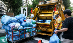Des habitants de Taipei à Taïwan aidant les éboueurs à jeter leurs ordures dans la benne de leur camion, le 19 juin 2025 ( AFP / I-Hwa Cheng )