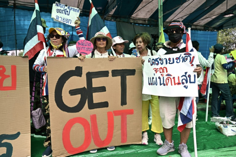 Des manifestants tiennent des pancartes appelant la Première ministre thaïlandaise Paetongtarn Shinawatra à démissionner, lors d'un rassemblement devant le palais du gouvernement, le 19 juin 2025 à Bangkok ( AFP / Lillian SUWANRUMPHA )