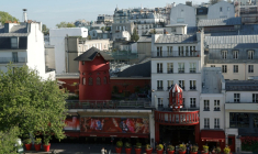 Le Moulin rouge le 25 avril 2024, à Paris avec à l'arrière à gauche l'appartement où vivait Jacques Prévert et à l'arrière au centre celui où vivait Boris Vian ( AFP / Geoffroy VAN DER HASSELT )