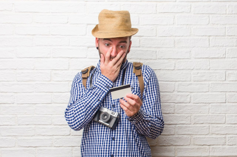 (Vacancier découvrant une mauvaise surprise avec sa carte bancaire utilisée à l'étranger - Crédits photo : Adobe Stock)