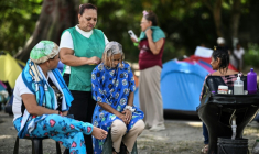 Melba Vazquez (au centre), mère du prisonnier politique Merwin Simons, reçoit un soin capillaire devant la prison Rodeo I où elle attend la sortie de son fils, le 25 janvier 2026 à Guatire, près de Caracas, au Venezuela ( AFP / Ronaldo SCHEMIDT )