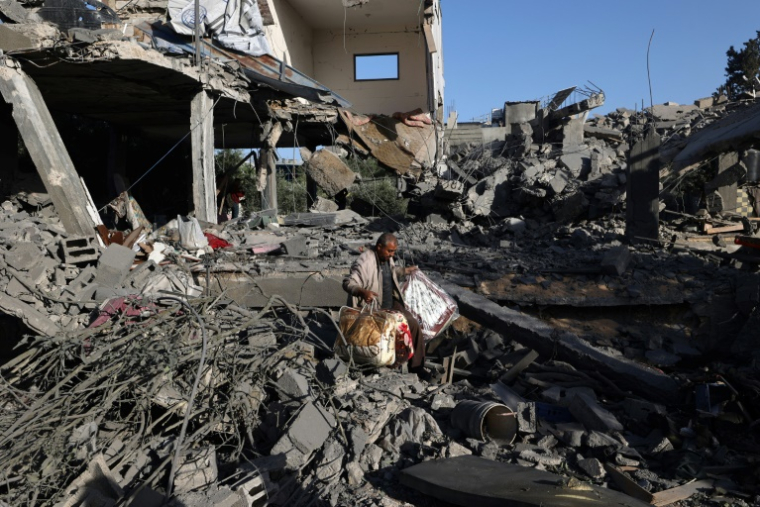 Un Palestinien récupère quelques biens dans une maison ciblée par une frappe israélienne dans le camp de réfugiés de Nousseirat, dans le centre de la bande de Gaza, le 24 mai 2025 ( AFP / Eyad BABA )