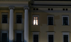 Une lumière est visible à une fenêtre du Palais royal alors que des personnes se rassemblent pour une veillée nocturne en l'honneur du roi Harald V de Norvège, sur la place du Palais à Oslo, tôt le 28 août 2026. ( AFP / Odd ANDERSEN )