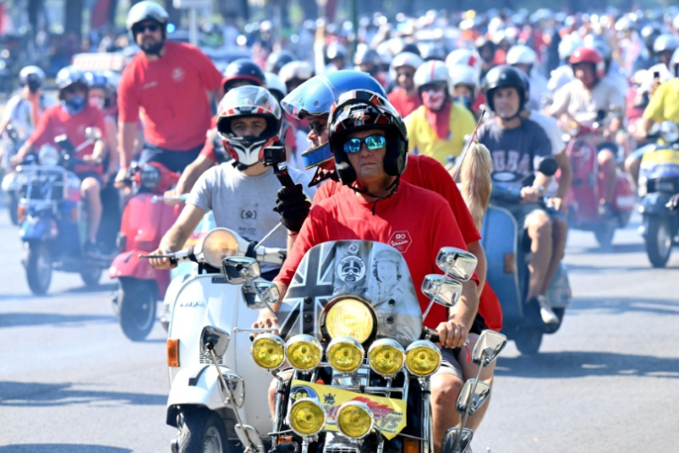 Des passionnés de Vespa participent à la parade des Vespa World Days, marquant le 80e anniversaire de la célèbre marque italienne de scooters, le 27 juin 2026 à Rome  ( AFP / Alberto PIZZOLI )