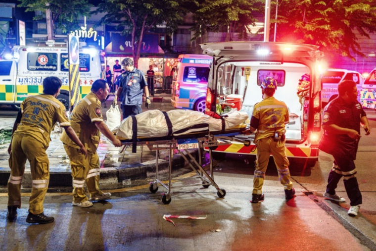Des secouristes évacuent le corps d'une victime de l'incendie du bar Rong Beer Na Lat Phrao à Bangkok, le 13 juillet 2026 en Thaïlande ( AFP / chanakarn LAOSARAKHAM )