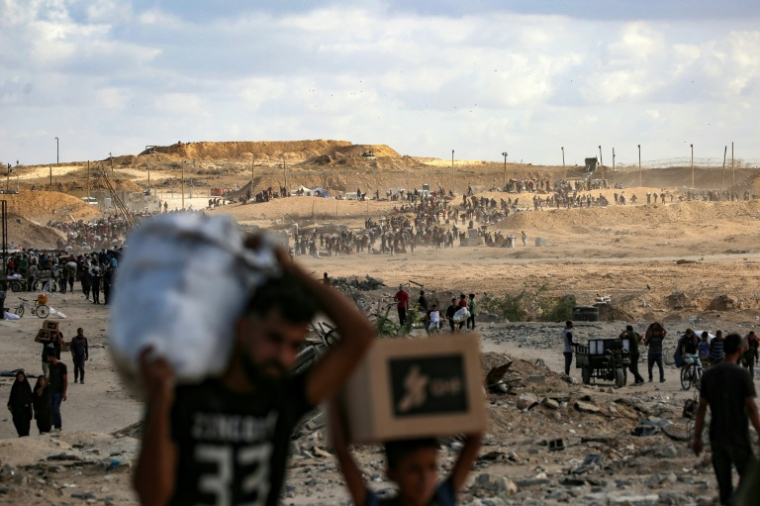 Des palestiniens transportent des sacs d'aide alimentaire au retour d'un point de distribution de l'organisation GHF le 5 Octobre 2025 dans le centre de la bande de Gaza. ( AFP / Eyad BABA )