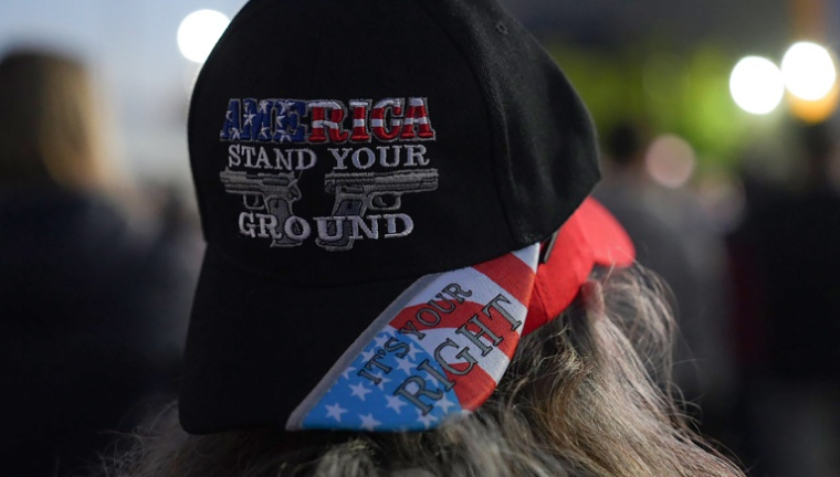 Une supportrice de Donald Trump portant une casquette sur laquelle est écrit "Amérique, défend ta position", lors d'un meeting du président républicain à Park City, dans le Kansas (centre des États-Unis), le 19 octobre 2026 ( AFP / Zina DESMAZES )