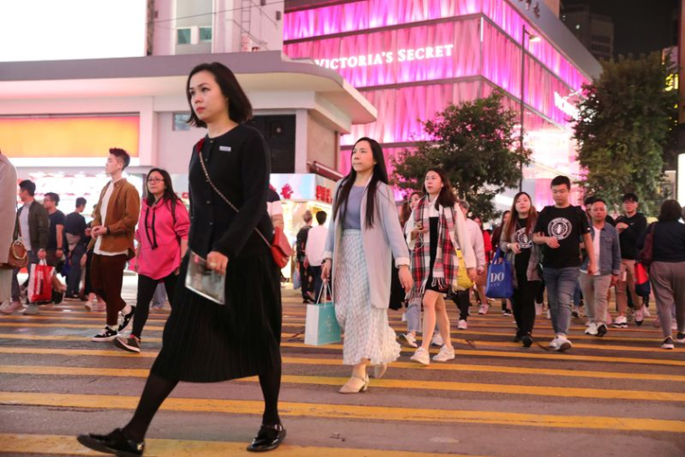 Des clients traversent la route à l'extérieur du centre commercial Causeway Bay à Hong Kong.