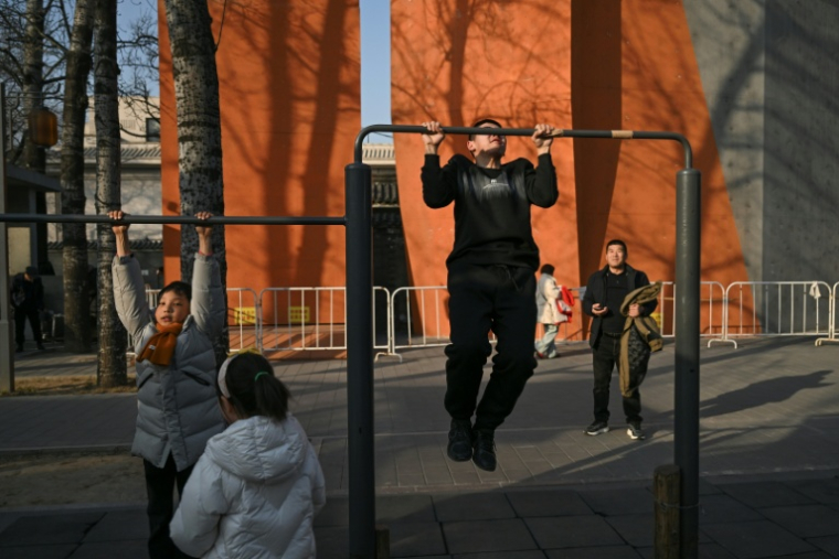 Des personnes font de l'exercice au parc Ritan à Pékin, le 4 février 2026 ( AFP / Pedro PARDO )