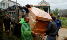 Des hommes transportent un cercueil contenant le corps d'une personne morte dans les inondations à Hoa Thinh, dans le centre du Vietnam, le 22 novembre 2025 ( AFP / STR )