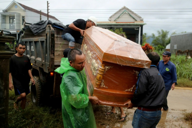 Des hommes transportent un cercueil contenant le corps d'une personne morte dans les inondations à Hoa Thinh, dans le centre du Vietnam, le 22 novembre 2025 ( AFP / STR )