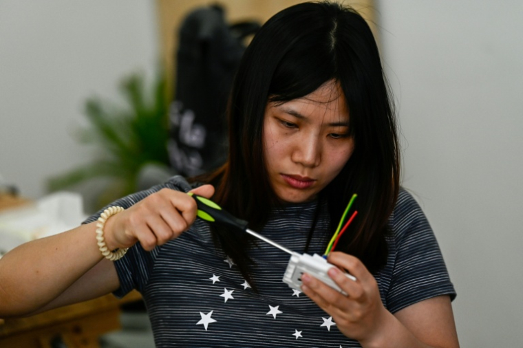 Une femme participe à un cours d'électricité organisé par l'atelier Mulan Build à Hangzhou, dans la province du Zhejiang, le 28 juin 2026 dans l'est de la Chine ( AFP / Pedro PARDO )