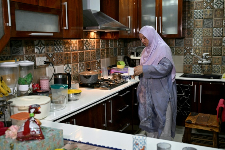 Saniya Jafri, médecin et praticienne en télémédecine pour la société de santé numérique Sehat Kahani, prépare du thé pendant une pause entre deux consultations en ligne à son domicile de Karachi, au Pakistan, le 7 avril 2026 ( AFP / Rizwan TABASSUM )