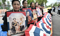 Des personnes en deuil tiennent des portraits de la défunte princesse thaïlandaise Bajrakitiyabha Mahidol devant le Grand Palais de Bangkok, le 13 juin 2026 ( AFP / Lillian SUWANRUMPHA )