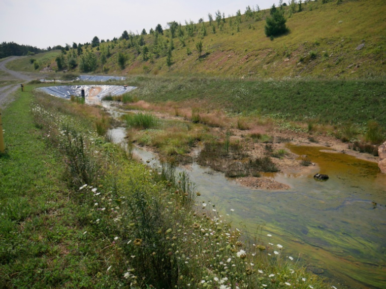 Un bassin de collecte des eaux polluées d'une ancienne mine de charbon près de l'installation de traitement de drainage minier acide de l'Université de Virginie-Occidentale, le 12 août 2026 à Mount Storm en Virginie-Occidentale (Etas-Unis) ( AFP / Pierre HARDY )
