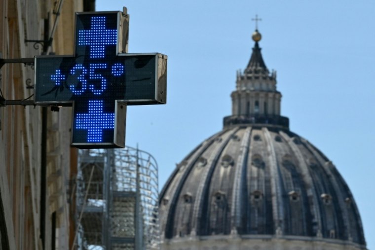 Le thermomètre d'une pharmacie affiche 35 degrés Celsius, avec en arrière plan le dôme de la basilique Saint-Pierre, à Rome en pleine vague de chaleur le 26 mai 2026 ( AFP / Alberto PIZZOLI )