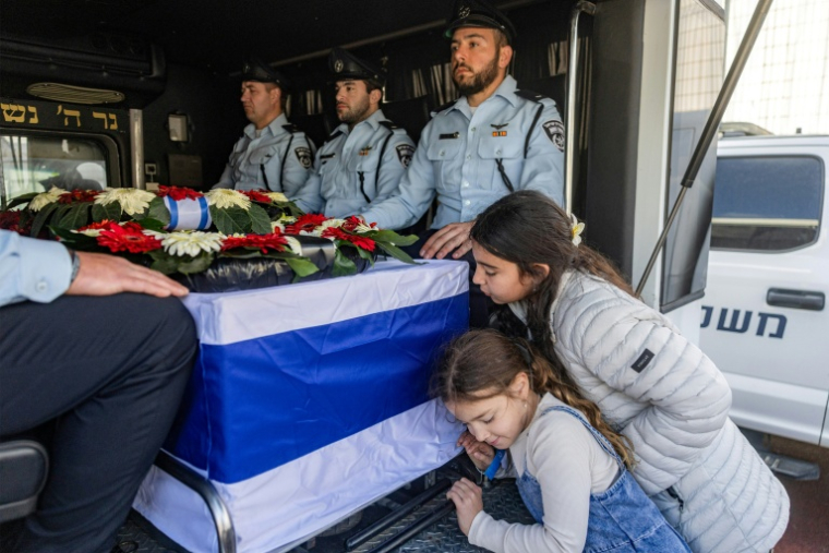 Des enfants se penchent sur le cercueil de Ran Gvili, lors de ses funérailles à Meitar, dans le sud d'Israël, le 28 janvier 2026 ( POOL / Chaim Goldberg )