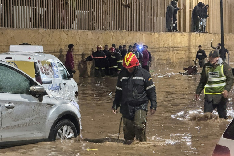 Des personnes pataugent dans  une rue de la ville côtière marocaine de Safi après une crue soudaine causée par des pluies torrentielles, le 14 décembre. ( AFP / - )