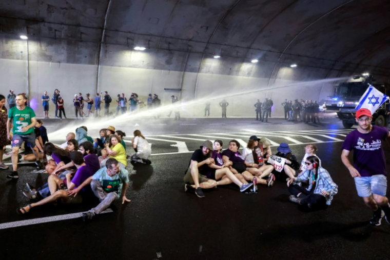 La police israélienne utilise un canon à eau pour disperser des manifestants bloquant la circulation dans un tunnel à Jérusalem, le 17 août 2025 ( AFP / Menahem Kahana )