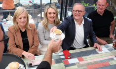 Le Premier ministre australien Anthony Albanese se fait servir un café au côté de sa compagne Jodie Haydon, le 4 mai 2025 à Sydney ( AFP / DAVID GRAY )