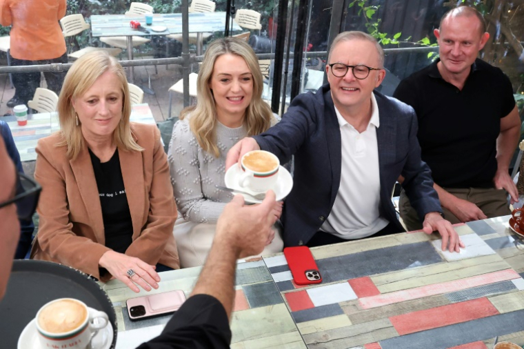 Le Premier ministre australien Anthony Albanese se fait servir un café au côté de sa compagne Jodie Haydon, le 4 mai 2025 à Sydney ( AFP / DAVID GRAY )