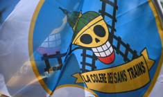 Un drapeau, inspiré d'un manga, portant l'inscription "la colère des sans trains" déployé devant le jardin du Luxembourg près du Sénat où sera discuté à partir de mercredi le projet de loi-cadre sur les Transports, le 14 avril 2026. ( AFP / JULIEN DE ROSA )