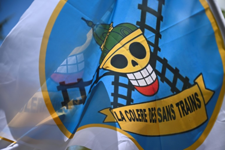 Un drapeau, inspiré d'un manga, portant l'inscription "la colère des sans trains" déployé devant le jardin du Luxembourg près du Sénat où sera discuté à partir de mercredi le projet de loi-cadre sur les Transports, le 14 avril 2026. ( AFP / JULIEN DE ROSA )