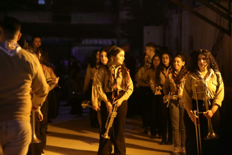 Des Scouts musiciens préparent les célébrations de Noël dans la cour d'une église de Damas, le 23 décembre 2025 en Syrie ( AFP / Bakr ALKASEM )