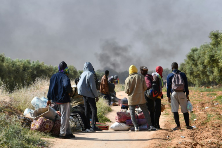 Des migrants d'Afrique subsaharienne observent la destruction de leur camp de fortune à El Amra, en Tunisie, le 5 avril 2025 ( AFP / FETHI BELAID )