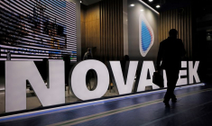 Un participant à un forum passe devant un stand du producteur de gaz russe Novatek