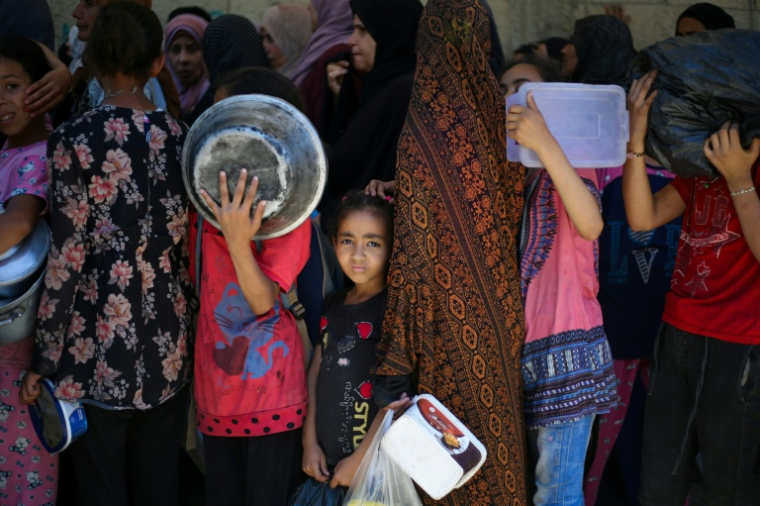 Des enfants attendent dans un centre de distribution d'aide humanitaire à Nousseirat, dans le centre de la bande de Gaza, le 2 juin 2025 ( AFP / Eyad BABA )