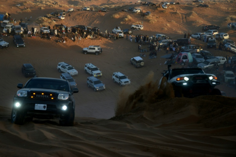 Des passionnés d'automobile conduisent des 4X4 dans les dunes de la province de Kandahar, le 5 décembre 2025 en Afghanistan ( AFP / Sanaullah SEIAM )