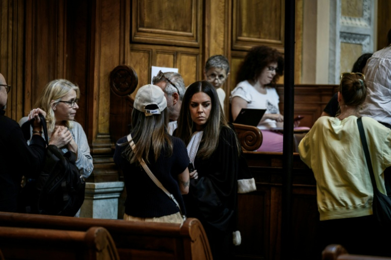 L'avocate de la partie civile Julia Studient (C) s'entretient avec sa cliente avant l'ouverture du procès à Lyon, le 11 juin 2026 ( AFP / Jeff PACHOUD )